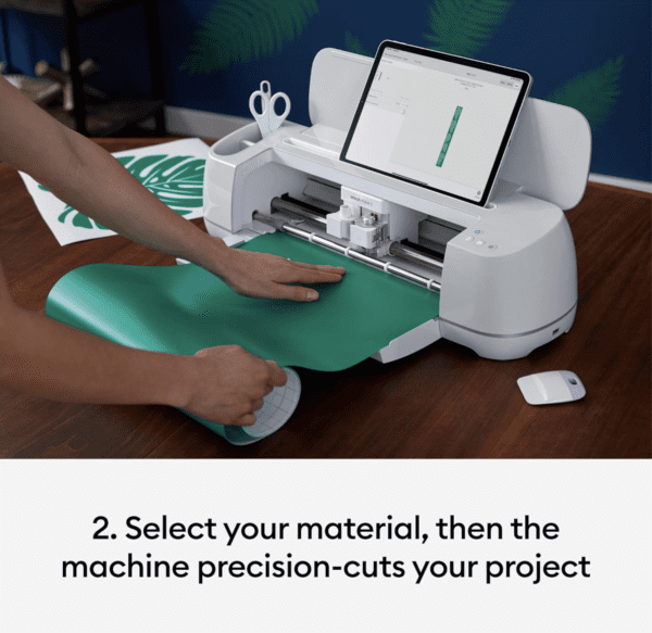 A person using the cricut maker to cut paper.